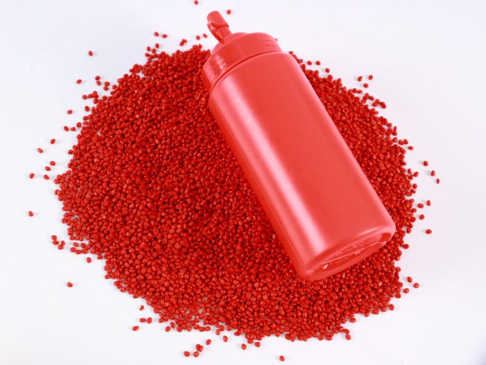 A container filled with Mega Plast's red masterbatch, ideal for achieving bold and eye-catching plastic applications